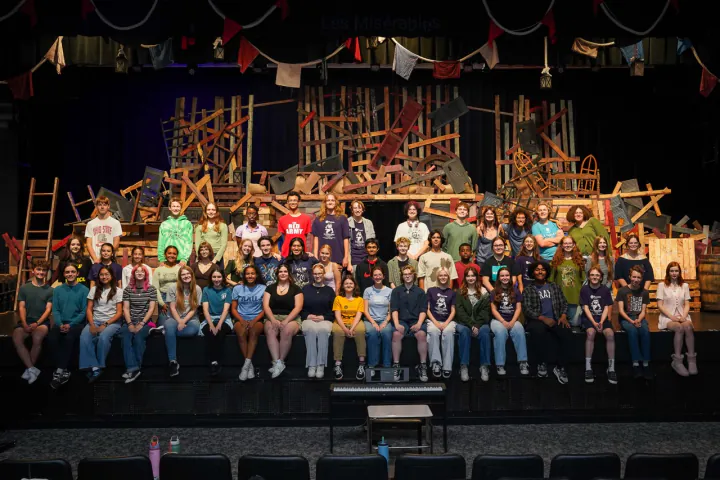 Westerville South Theatre students gather onstage in front of the Les Misérables set.