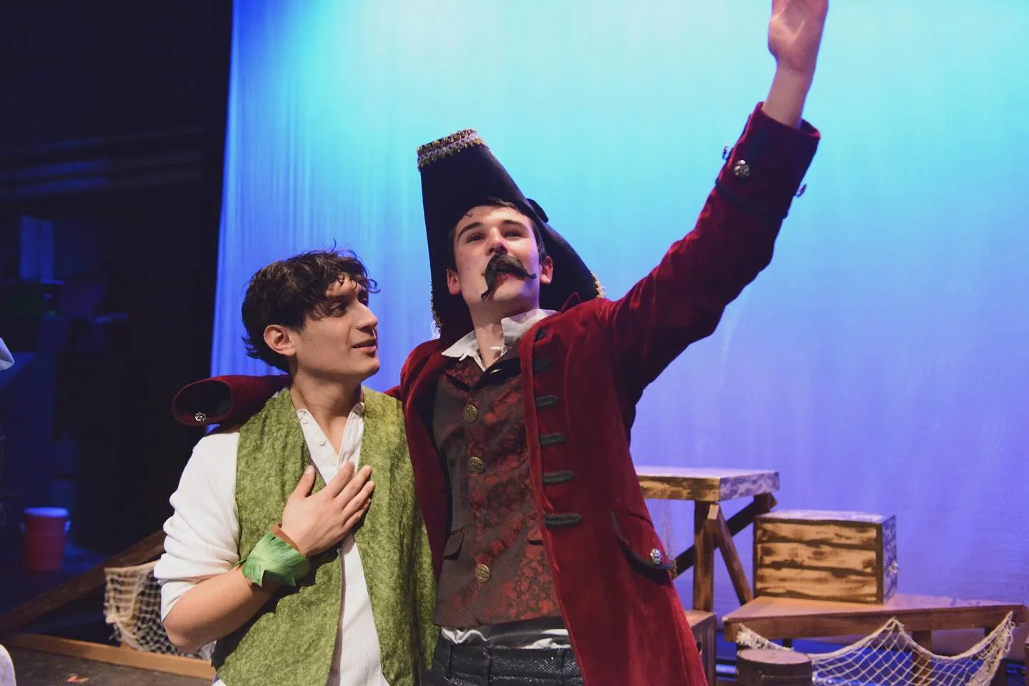 Black Stache raises one arm beside the Boy during a performance of Peter and the Starcatcher.