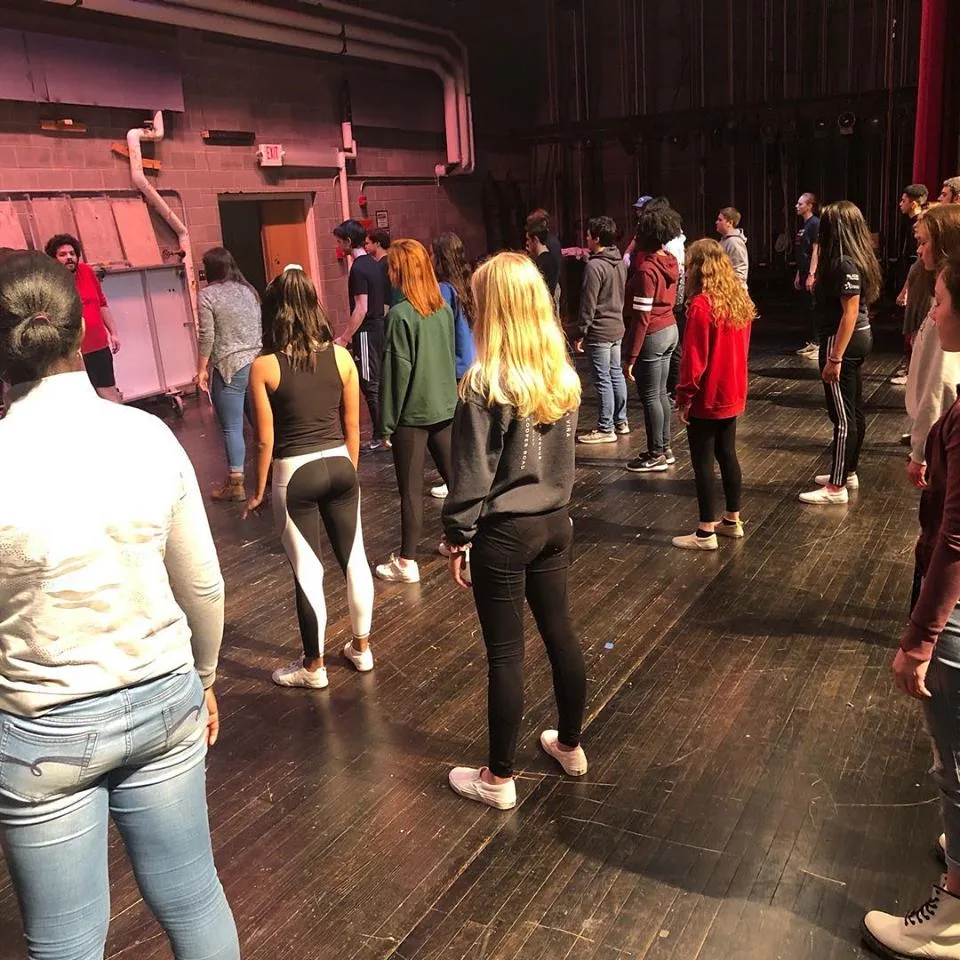Troupe 513 students rehearse together onstage with SMJ